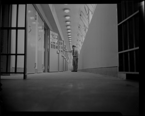 Prison guard standing at a row of cells