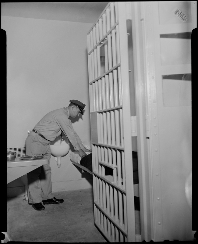 Guard Raymond Mazetis fixing the bed in a cell