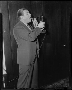 Morton Downey speaking into a telephone