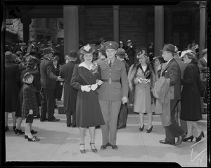 Eleanor Van Kleek, fiancé, and Arthur Mitton Jr. standing together with a crowd of people in the background