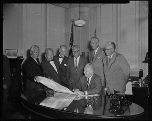 Mayor Collins, seated, reviews plans for the new North Terminal with Comr. Of Dept. of Commerce, John T. Burke; Deputy Comr. Of Dept. of Commerce, J. F. Reynolds; Mass. Port Authority chairman, Ephraim Brest; MDC, Patrick G. Sullivan; and vice chairman, Port Authority, Carl J. Gilbert