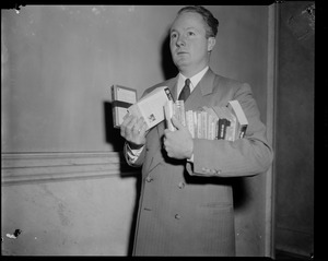 Senator John F. Collins with books in his arms during the State House Anti-Filthy Book Bill Hearing