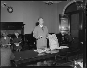Senator John F. Collins behind a table of books during the State House Anti-Filthy Book Bill Hearing