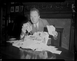 Senator John F. Collins (D) of Roxbury with coupons mailed from Record-American readers opposed to a 20-cent increase in MTA fare