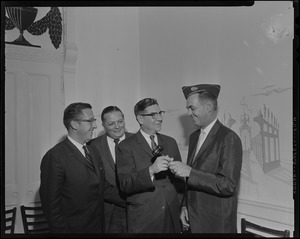 Mark F. Collins, assistant publisher of Boston Record-American receives a gavel from Thomas Orthman as Jack Drummey and Paul Bishop look on