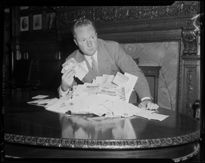 Senator John F. Collins (D) of Roxbury with coupons mailed from Record-American readers opposed to a 20-cent increase in MTA fare