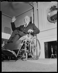 Mayor John F. Collins waving in front of the fireplace
