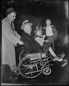 A man pushes Mayor John F. Collins with his daughter Peggy sitting his lap