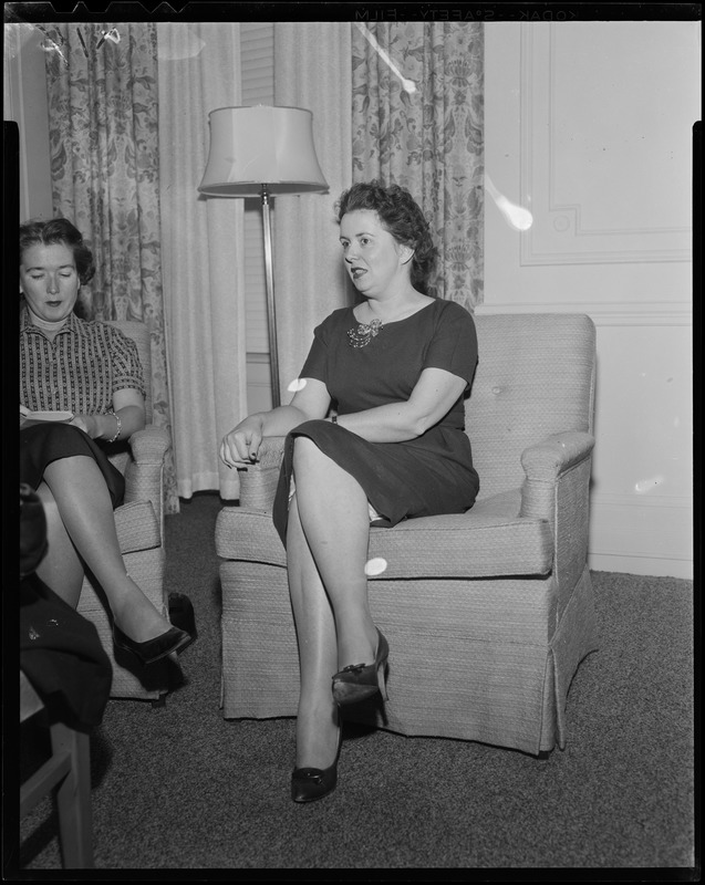 Mary Collins seated, talking with another woman