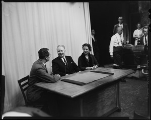 Mayor-elect John F. Collins speaking with a man on his right while his wife, Mary, on his left, looks on