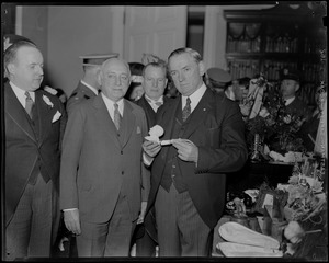 Governor James M. Curley holding a pipe and standing next to another man