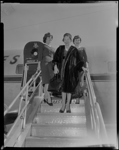 Lana Turner exiting airplane next to two flight attendants