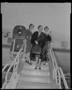 Lana Turner exiting airplane next to two flight attendants upon arrival to Logan International Airport