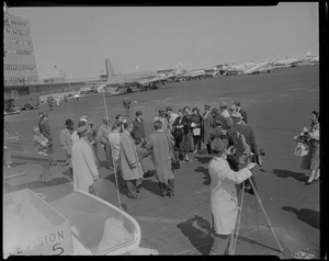 Lana Turner standing with others standing on tarmac upon arrival at Logan International Airport