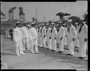 Captain G.T. Ferguson, Captain J.F. Enright and Lefteris Lavrakas walk by a row of sailors during the U.S.S. Boston change of command ceremonies