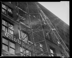 Scaffolding on the old Globe building with an oversized item being hoisted down