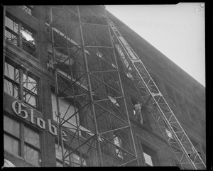 Scaffolding on the old Globe building with an oversized item being hoisted down