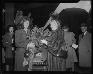Woman presents Lana Turner with a bouquet