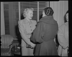 Lana Turner standing and talking with a woman