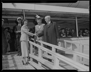 Woman shaking Mayor Curley's hand, near the ship entrance