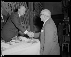 A man shakes hands with William Randolph Hearst Jr. at the Somerset Hotel