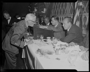 Man in uniform leaning over to talk to William Randolph Hearst Jr. at the reception at Somerset Hotel