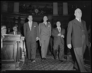 John Thompson and William Randolph Hearst Jr. walking down the aisle with members of the Legislature