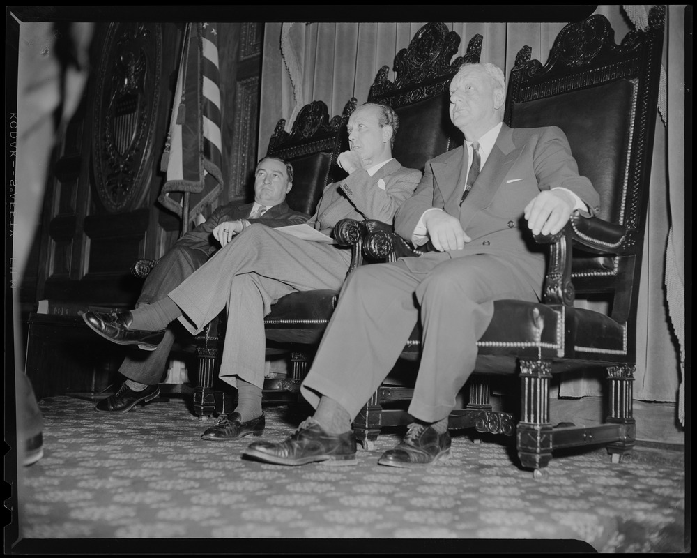 William Randolph Hearst Jr. and two others sitting in the chairs of the Legislature
