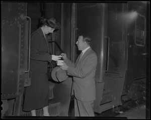 A man giving a gift to a woman descending a train