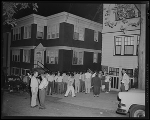 A crowd of people standing outside of Sam Silverman's Chelsea home which was bombed