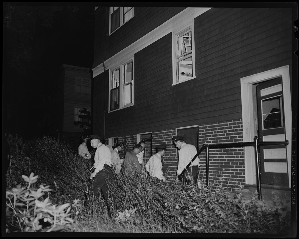 A group of officers and people standing beside a house - Digital ...