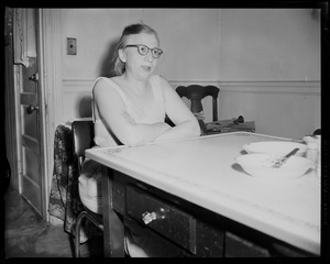 A woman sitting at a table in a house