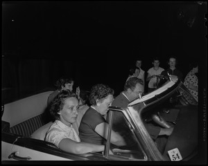 A group of people sitting inside of a car