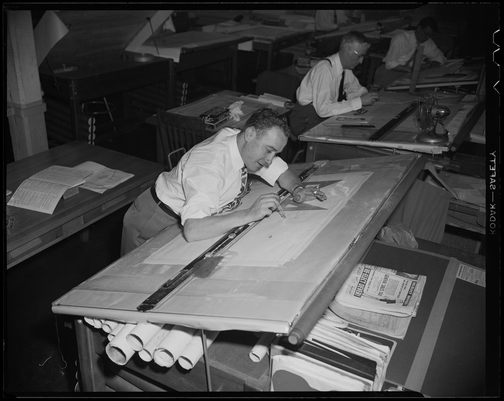 A man at a drafting desk using a protractor