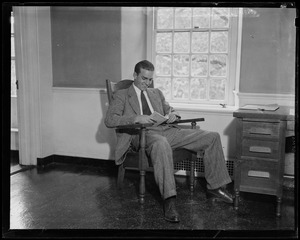 Randolph Hearst sitting in chair with a book