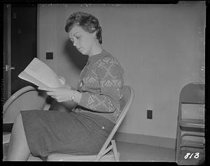 Woman reading manuscript from side