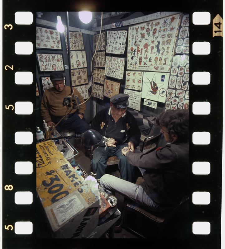 Stoic tattoo customer at county fair, Rochester, NH Digital Commonwealth