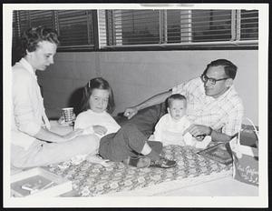 Mr. and Mrs. J. R. Thomas of Arlington, Va., and daughters Laura, 31/2. and Kathy, 7 months, take refuge in Ezra Baker School, West Dennis.
