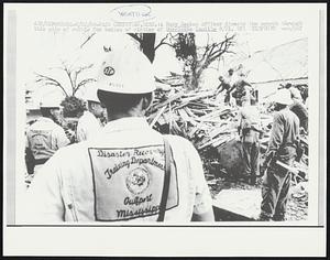 Pass Christian, Miss.: A Navy Seabee officer directs the search through this pile of rubble for bodies of victims of Hurricane Camille 8/21. Weather.