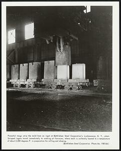 Powerful tongs strip the mold from an ingot at Bethlehem Steel Corporation’s Lackawanna, N. Y. plant. Stripped ingots travel immediately to soaking pit furnaces, where each is uniformly heated to a temperature of about 2,200 degrees F. in preparation for rolling and shaping.