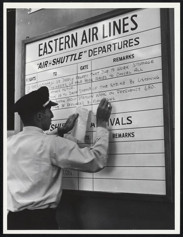 Eastern Air Lines departure board on which an employee is writing about the flight engineer work stoppage