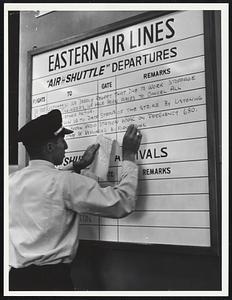 Eastern Air Lines departure board on which an employee is writing about the flight engineer work stoppage