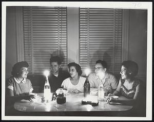 Still Candle-Lit Here -- A small pocket of blackness surrounded by restored lights in one part of Dorchester shows this family at 301 Fuller St. still in the twilight stage. Left to right, Mrs. Joseph Goldberg, Stephen Lewy, Mrs. Lewy, Harry Belinsky, Mrs. Belinsky.