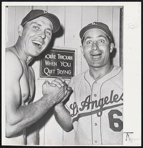Gil Hodges (Left) and Carl Furillo come to grips in joy as the Los Angeles Dodgers moved into first place in the National League by sweeping the three-game series with the San Francisco Giants. The Sunday 8-2 win moved the Dodgers into first place and dropped the Giants into third place, half a game behind the Milwaukee Braves. The sign, or motto, seems to have inspired the Dodgers.