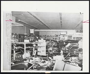 Wrecked Hardware Store -- An automobile is shown washed inside a hardware store in downtown Crescent City after being hit by a tidal wave caused by an earthquake in Alaska.