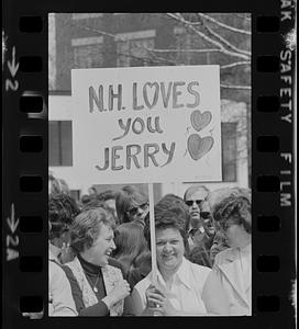 Woman in crowd holding sign during President Gerald Ford's visit in Concord, New Hampshire