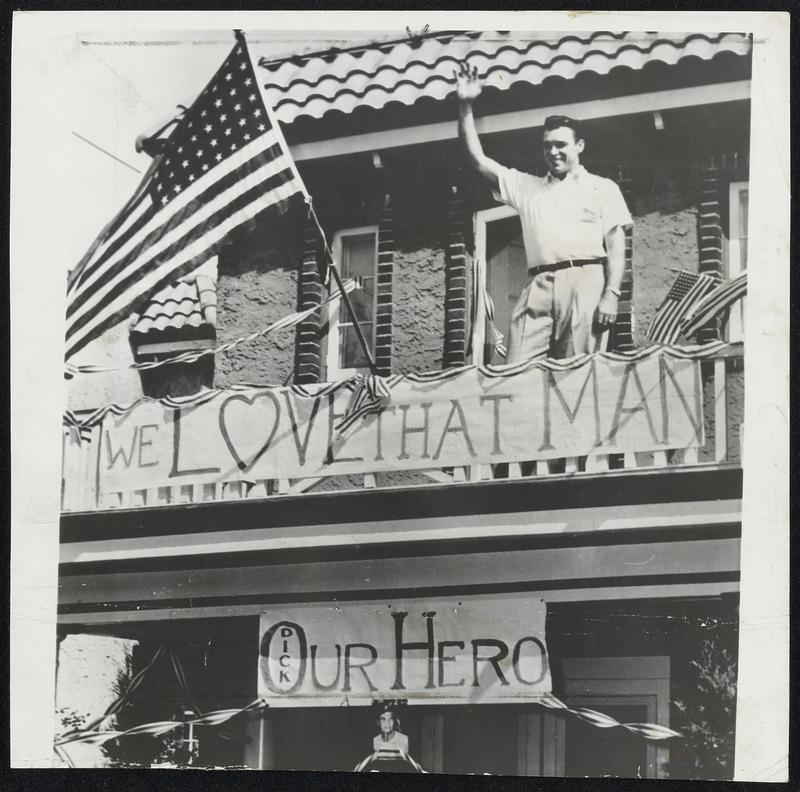 Honor in Home Town comes to the Phillies' Dick Sisler upon returning to his Norristown, Pa. home after hitting pennant-winning home run against the Dodgers. Dick waves happily from the second-story porch of his home that was decorated by jubilant