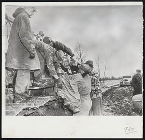 Grandmother Rescued - Mrs. Anna Covrig, 92 (center), is lifted aboard a tractor after her farm home near Bellevue, Neb., was threatened by the rising Missouri river. More than 20 farm families were evacuated from Bellevue, a suburb of Omaha, after a 12 square mile area was caught between the surging Missouri and Platte rivers.
