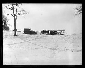A truck next to a group of people gathered around an airplane on the ground