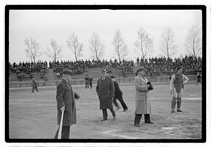 Boston Park Department Commissioner William Long looking at men holding baseball equipment